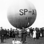 Pierwszy lot balonu „Sanok Autor: Leon Gottdank Czas wykonania: 21.06.1936 r. Fotografia przedstawia balon „Sanok” na sanockich błoniach nad Sanem. Wokół balonu zgromadzeni widzo-wie. Na balonie widoczne napisy: SP – ATN/ SANOK.